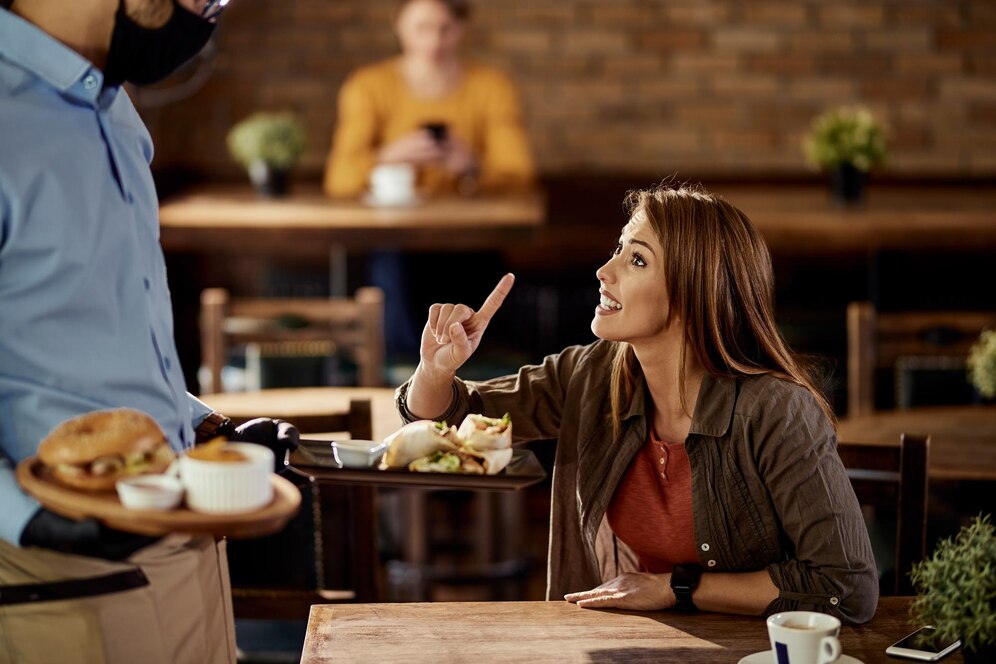 Diner offering their feedback to waiter, implying the role of its implementation in reputation management for a restaurant