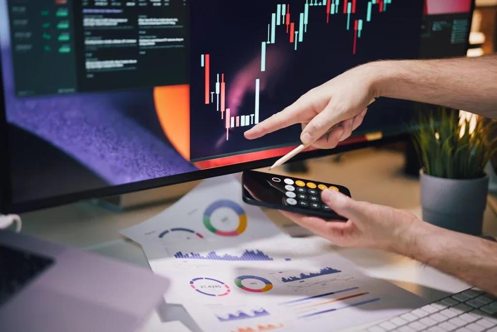 Hand pointing at financial chart, analyzing restaurant prime cost formula with calculator and data reports on desk