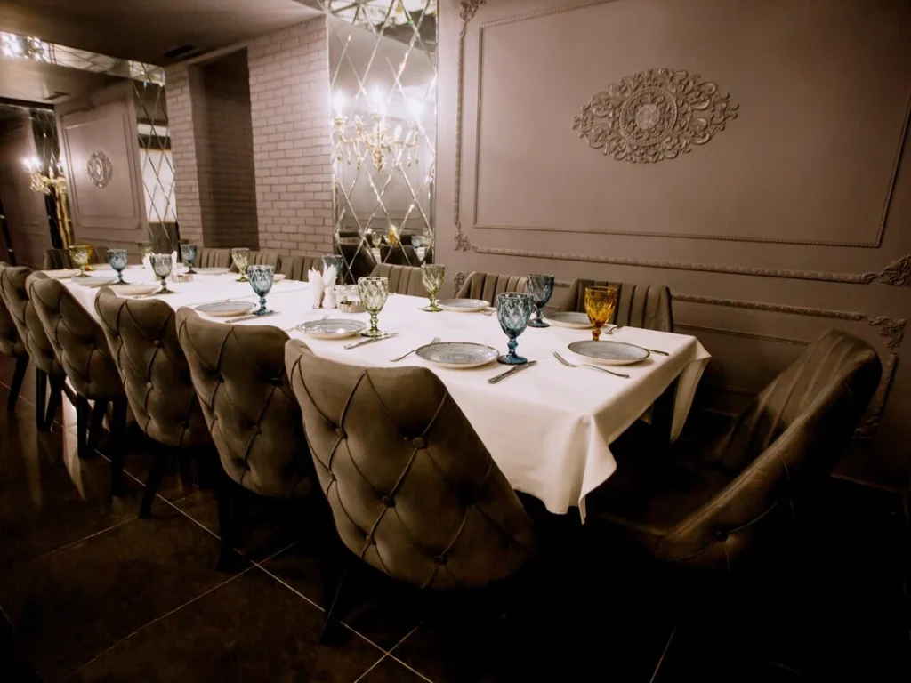 Fine dining setup showcasing how to create an enjoyable restaurant atmosphere with elegant decor, lighting, & plush seating